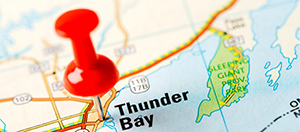 map with a push pin going through Thunder Bay
