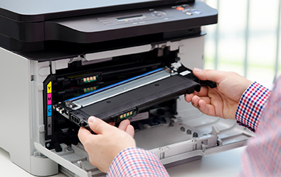 person inserting a toner cartridge into a printer