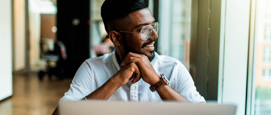 person at a laptop, resting face on hand holding fist