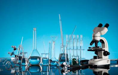 beakers, flasks, test tubes, microscope and other laboratory and science supplies laid out on a table