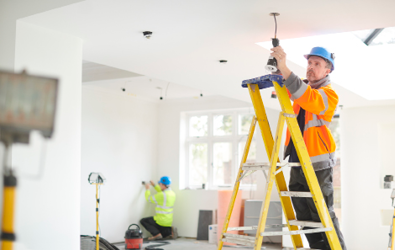 lighting contractor services, electrician installing a lighting fixture on a ladder