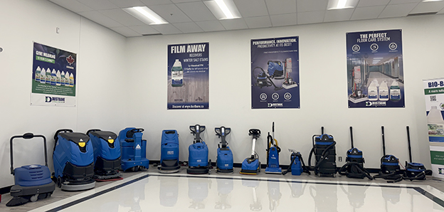 Row of Dustbane floor-care machines and vacuums displayed in a showroom