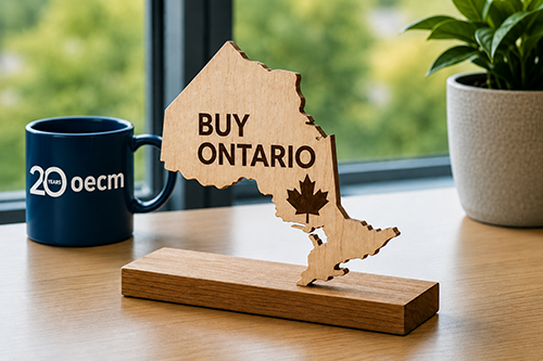 20 years OECM mug beside a wooden map shaped like Ontario that says Buy Ontario with a maple leaf