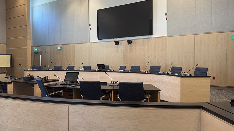 Council Chamber inside the new Town Hall, featuring council desks, seating and presentation screens.