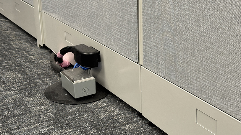 Workstation panels configured around existing electrical and data connections in the floor.