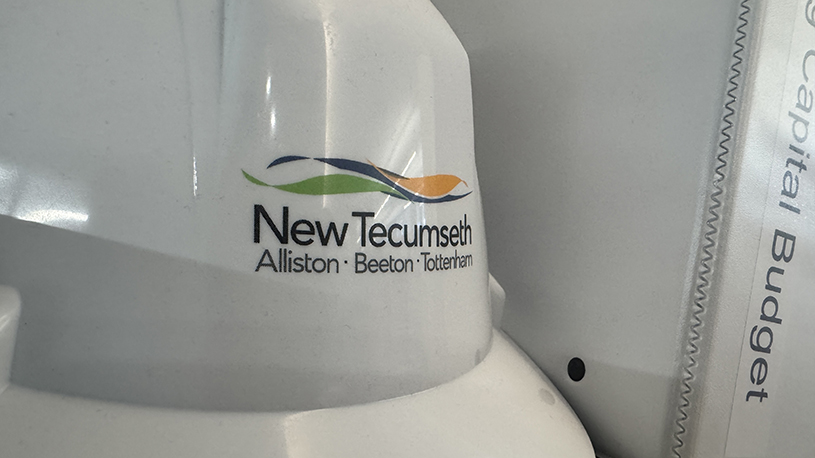 Town of New Tecumseth-branded chair beside a capital budget binder.
